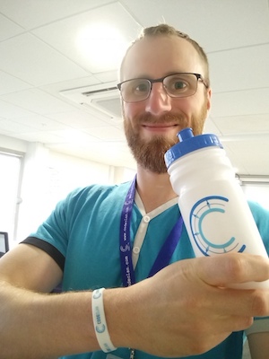 Callum holding CodeClan bottle in class