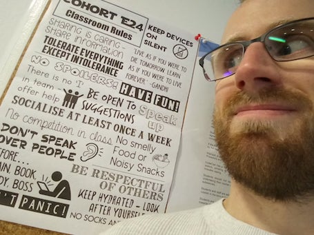 Callum face next to classroom rules poster